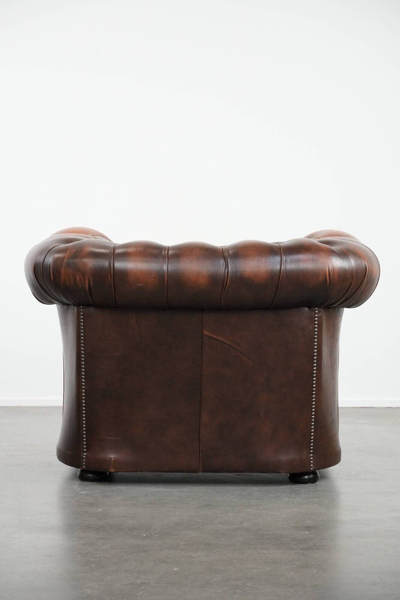 Brown Chesterfield armchair made of cowhide leather in English style