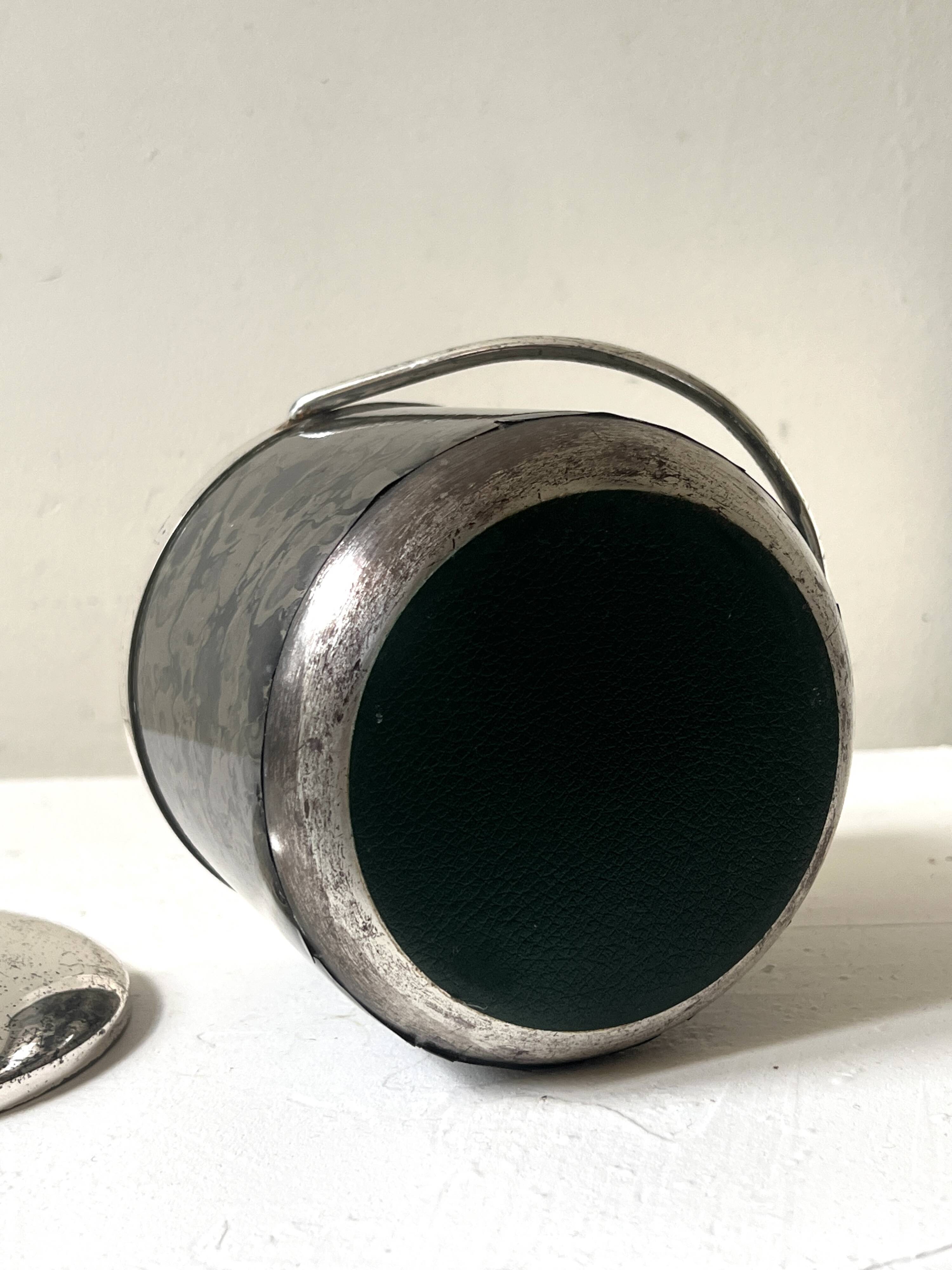 Vintage chrome metal ice bucket with black marbled design, 1970s style.