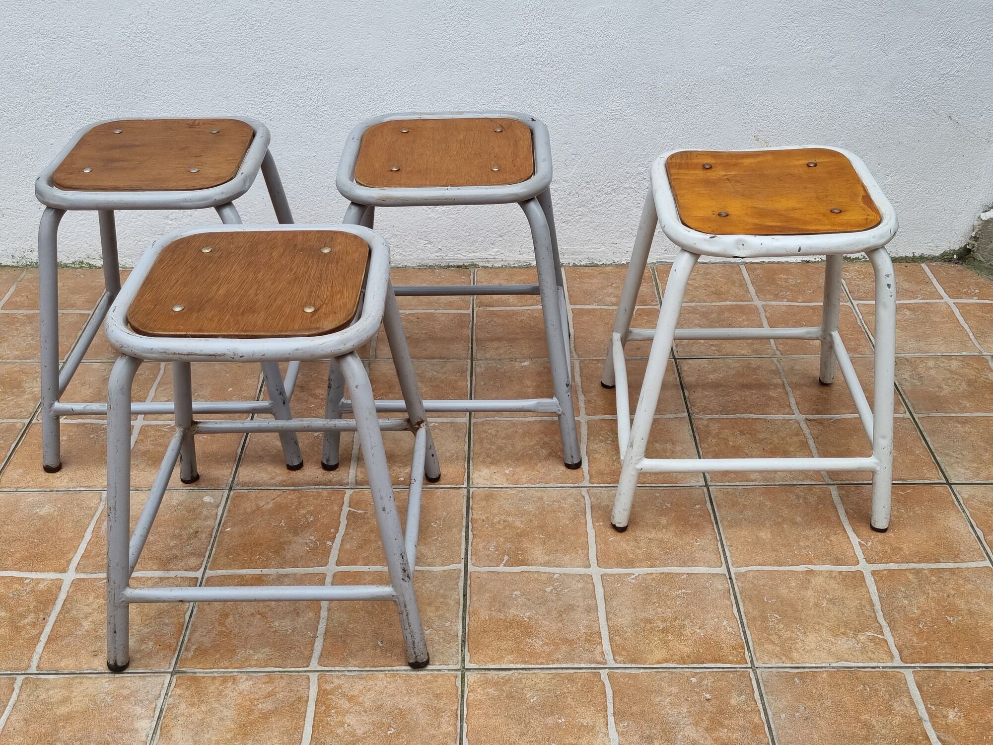 Set of four stackable industrial tubular metal and wood stools