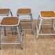Set of four stackable industrial tubular metal and wood stools