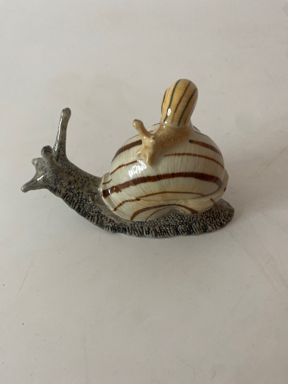 Porcelain figurine snail and its small
