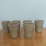 Set of 6 stoneware cups signed Cermer. Beige speckled, matte granular finish.