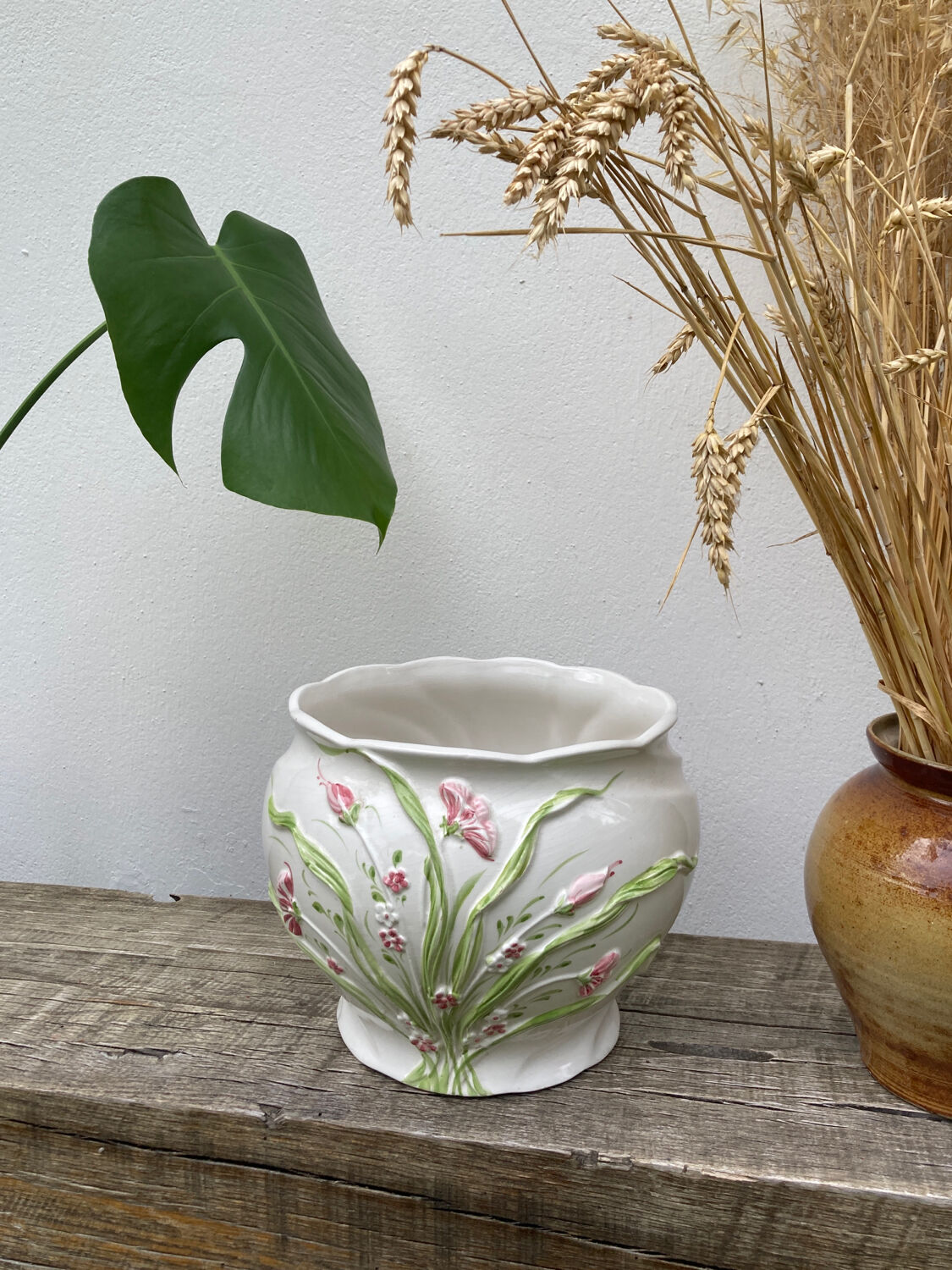 White ceramic pot cache of flower slip and old green foliage