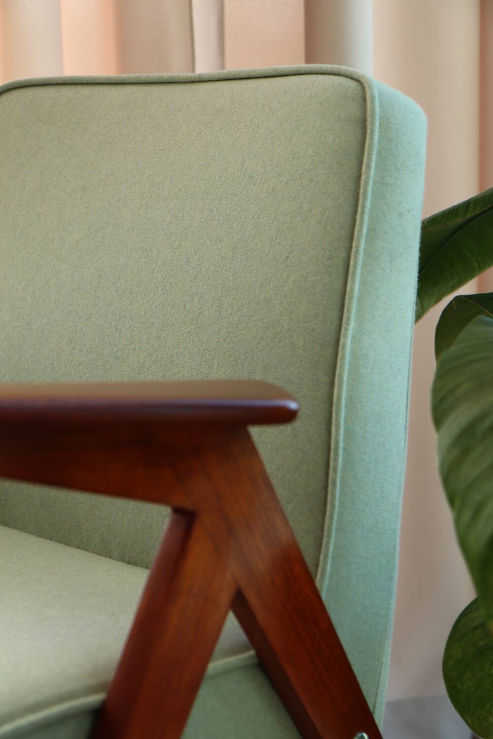 Vintage armchair in mint green wool, mid-century modern design.