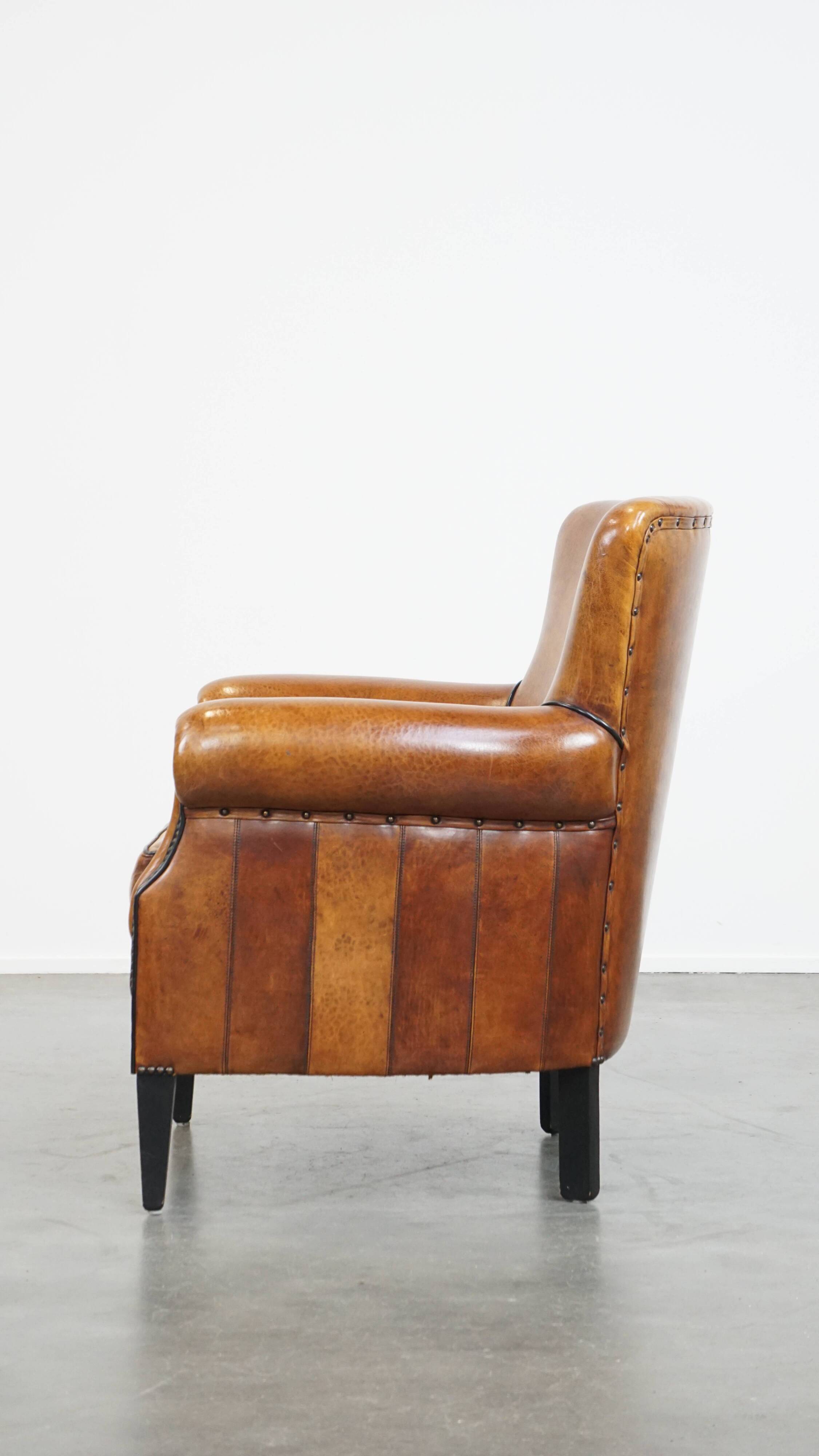 Cognac-colored sheep leather armchair finished with decorative nails