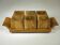 Six egg cups on a wooden tray.