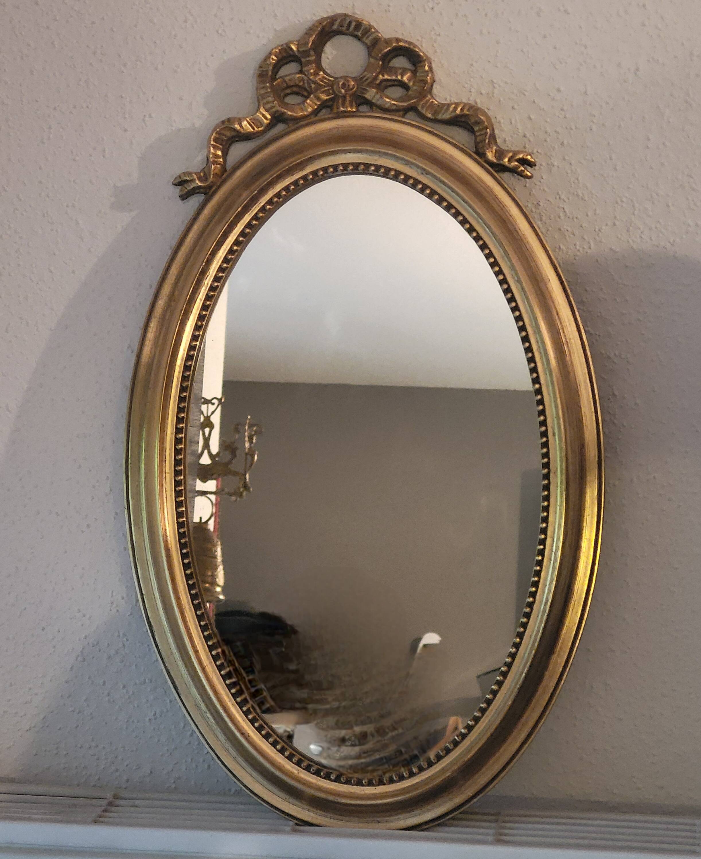 Oval mirror with golden wooden knot