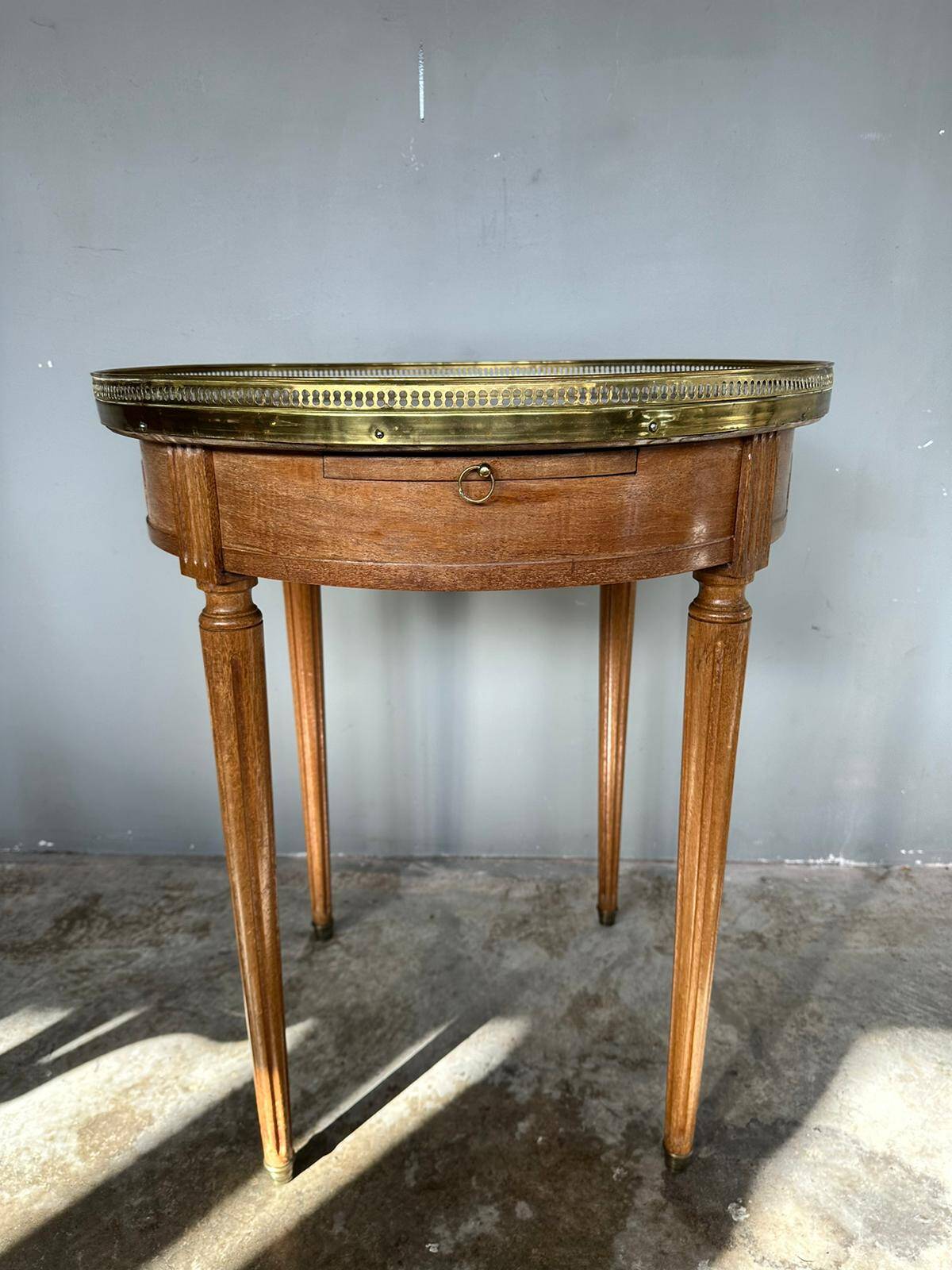 Hot water bottle table with a marble top and a brass gallery.