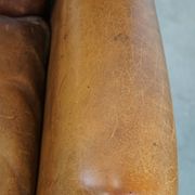 Cognac-colored sheep leather wingback chair finished with black piping
