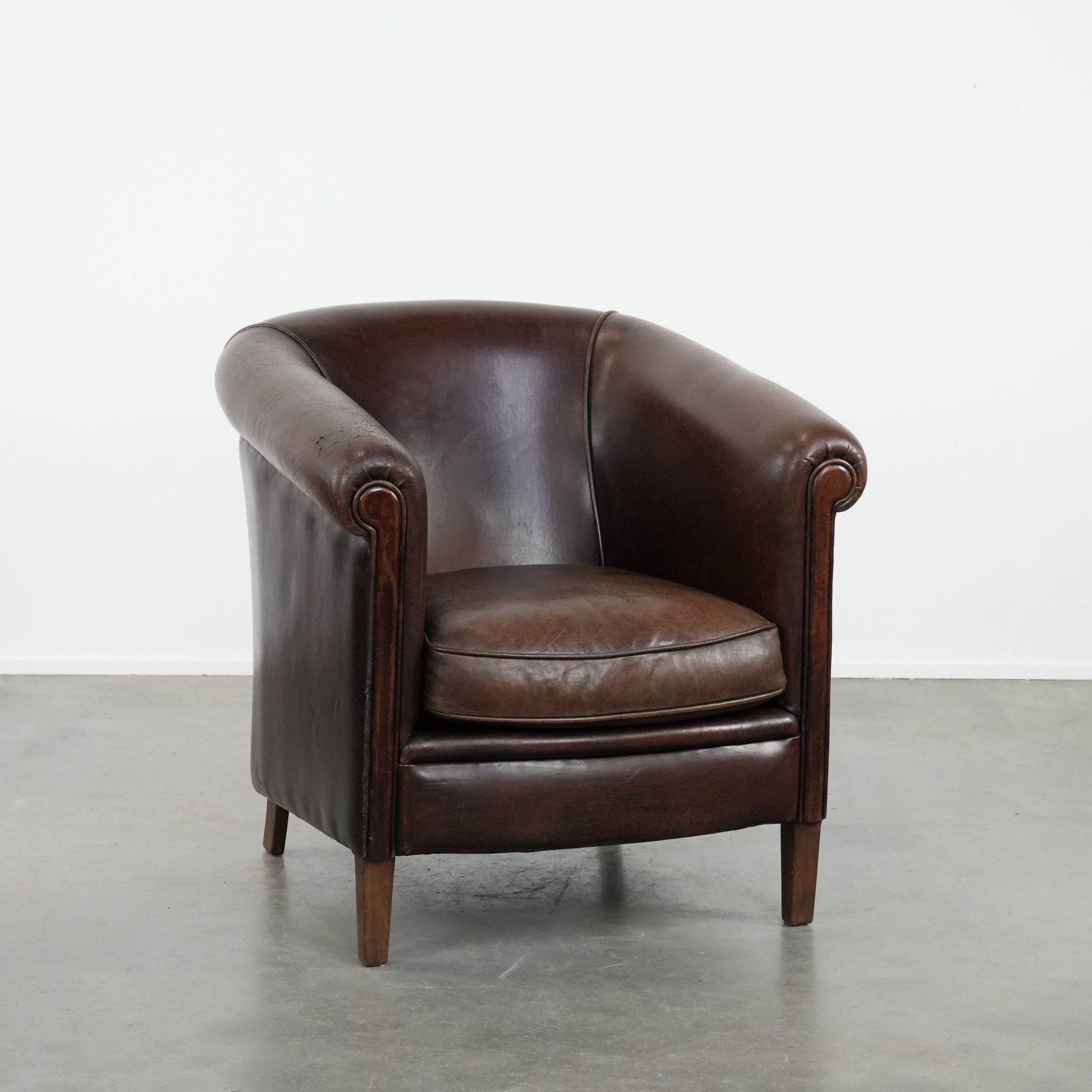 Stylish and sturdy dark brown club armchair made of sheepskin leather