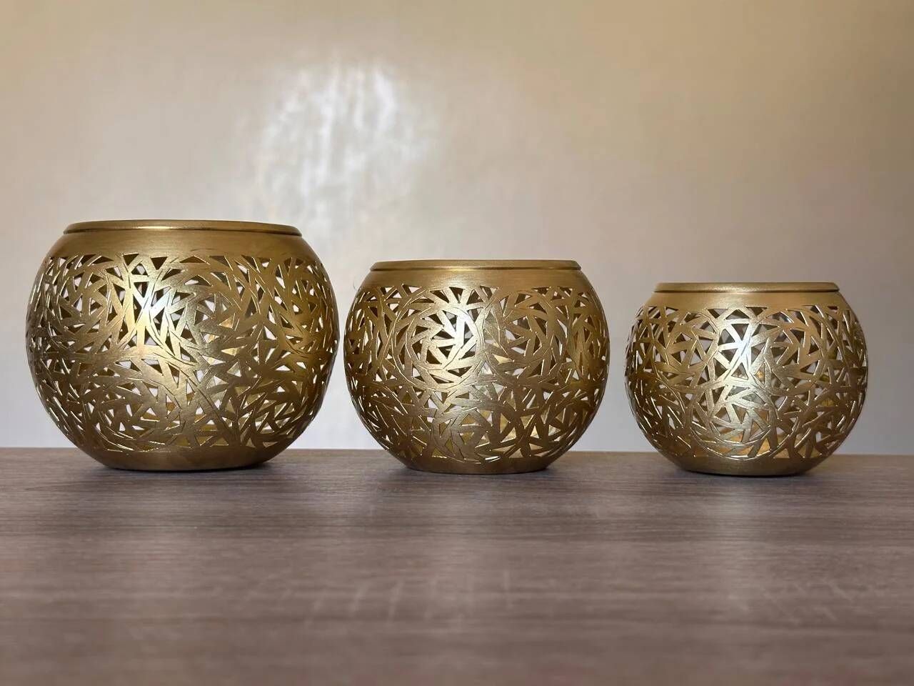 Set of 3 handmade brass candle holders with an openwork pattern.