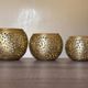 Set of 3 handmade brass candle holders with an openwork pattern.
