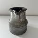 Patinated pitcher signed