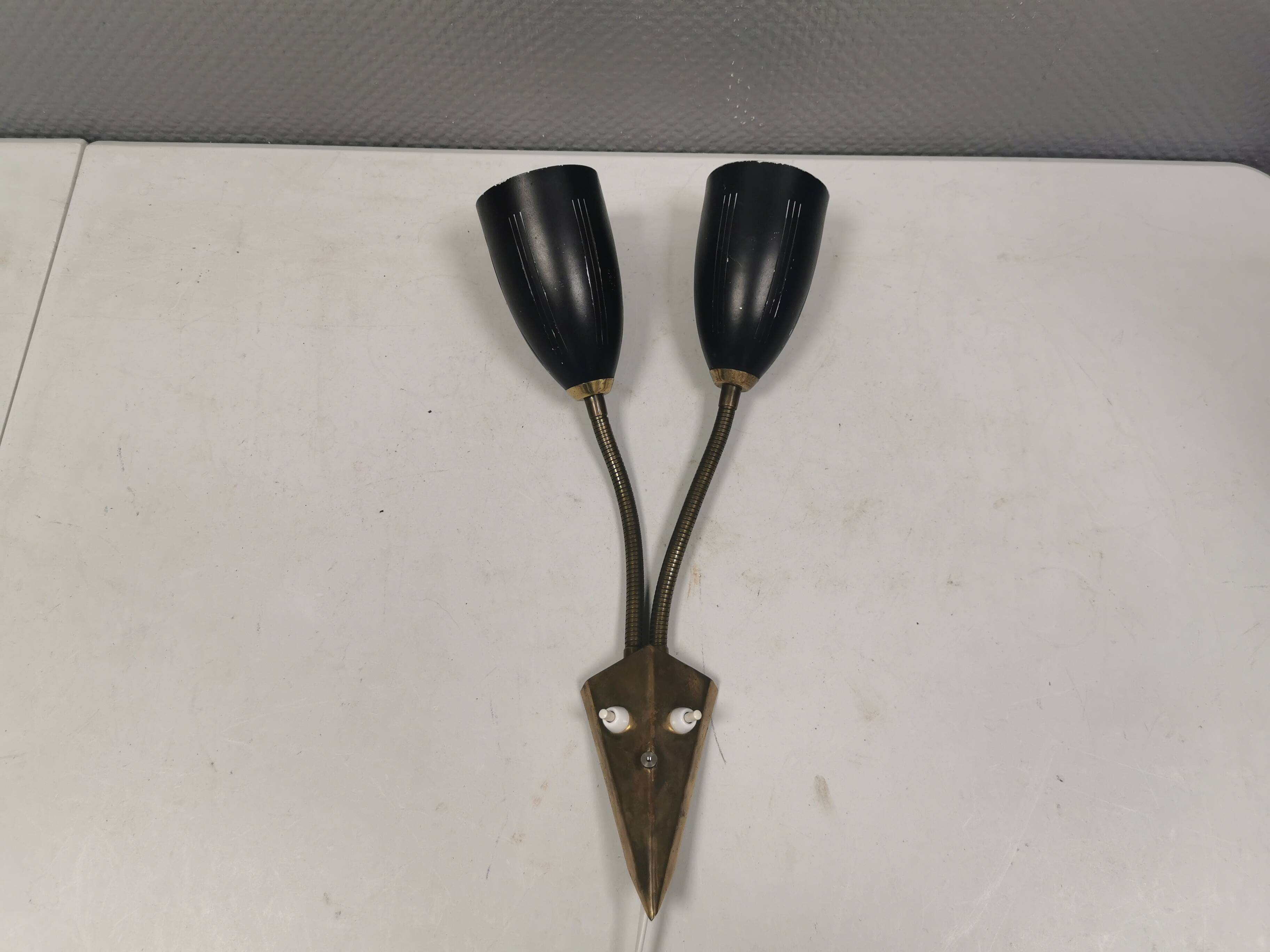 Older wall lamp with black metal shades and brass bend ‘arms’