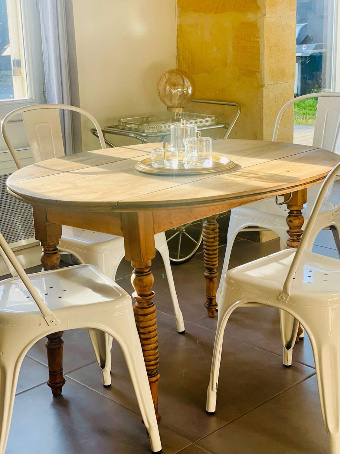 Oval wooden table with drop-leaf edges.