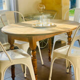 Oval wooden table with drop-leaf edges.