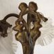 Double wall light in bronze in French Rococo style with white glass shades featuring patterns.