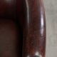 Vintage sheepskin club armchair with decorative nails and black piping