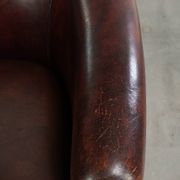 Vintage sheepskin club armchair with decorative nails and black piping