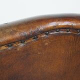 Sheepskin leather wingback chair with a red corduroy seat cushion