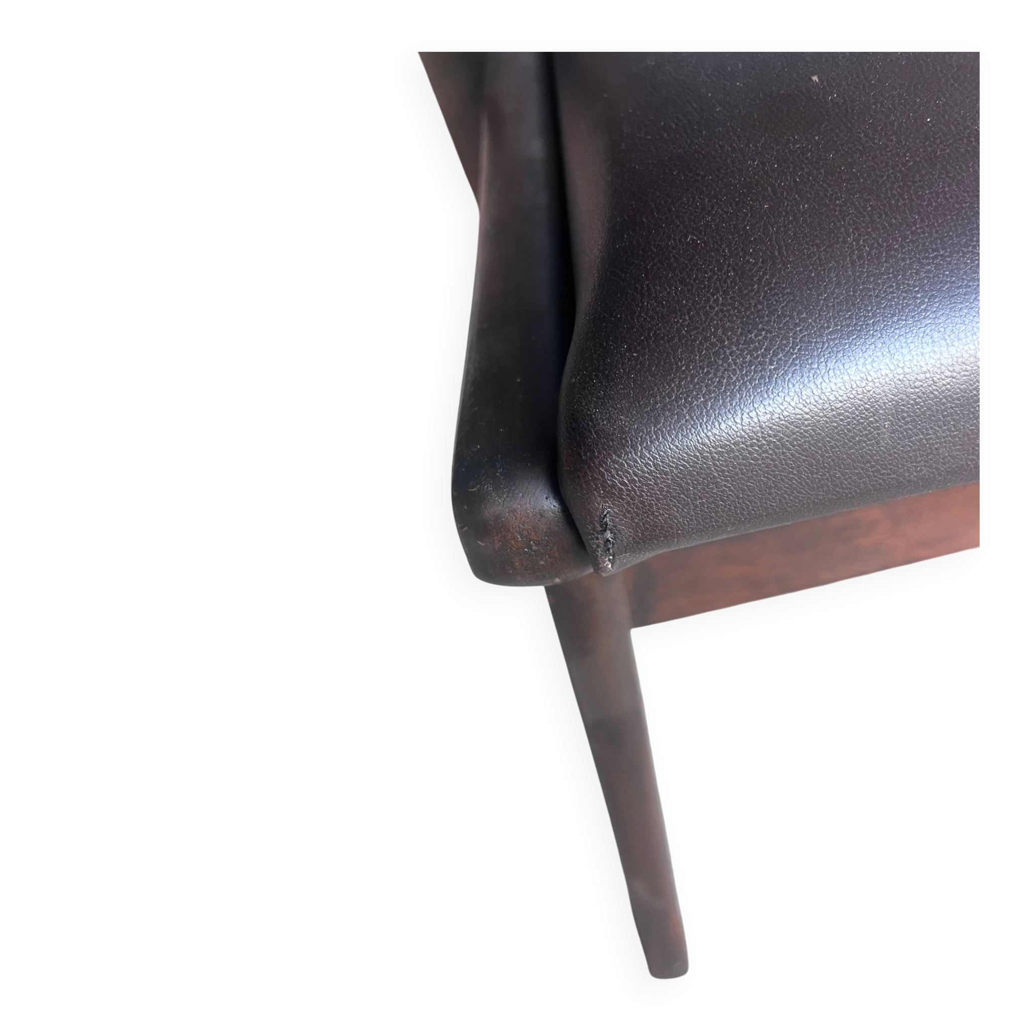 Pair of sculptural mid-century armchairs in dark wood and brown upholstery.