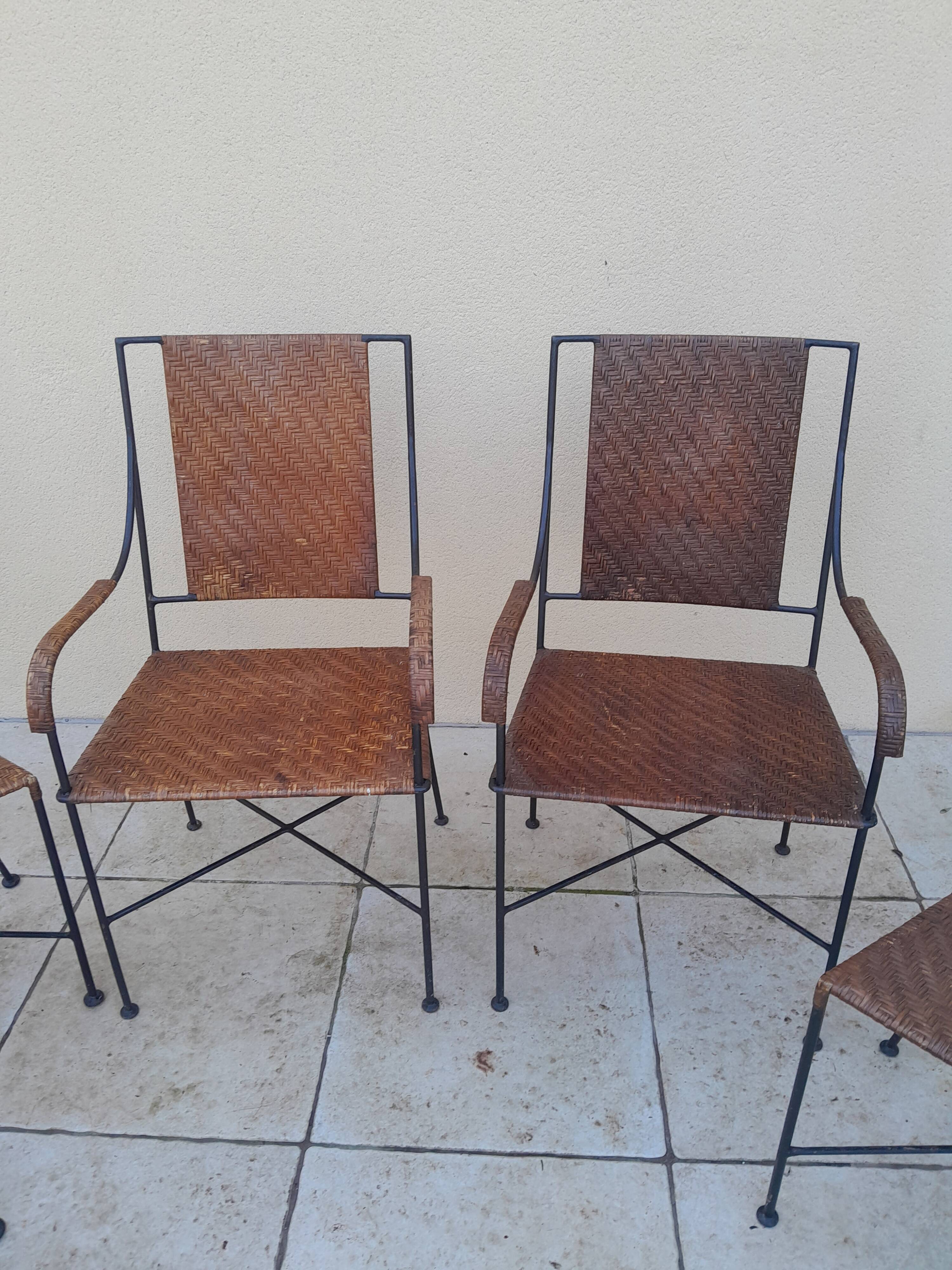 3 chairs and 2 armchairs in wrought iron and caned rattan, 1950s.