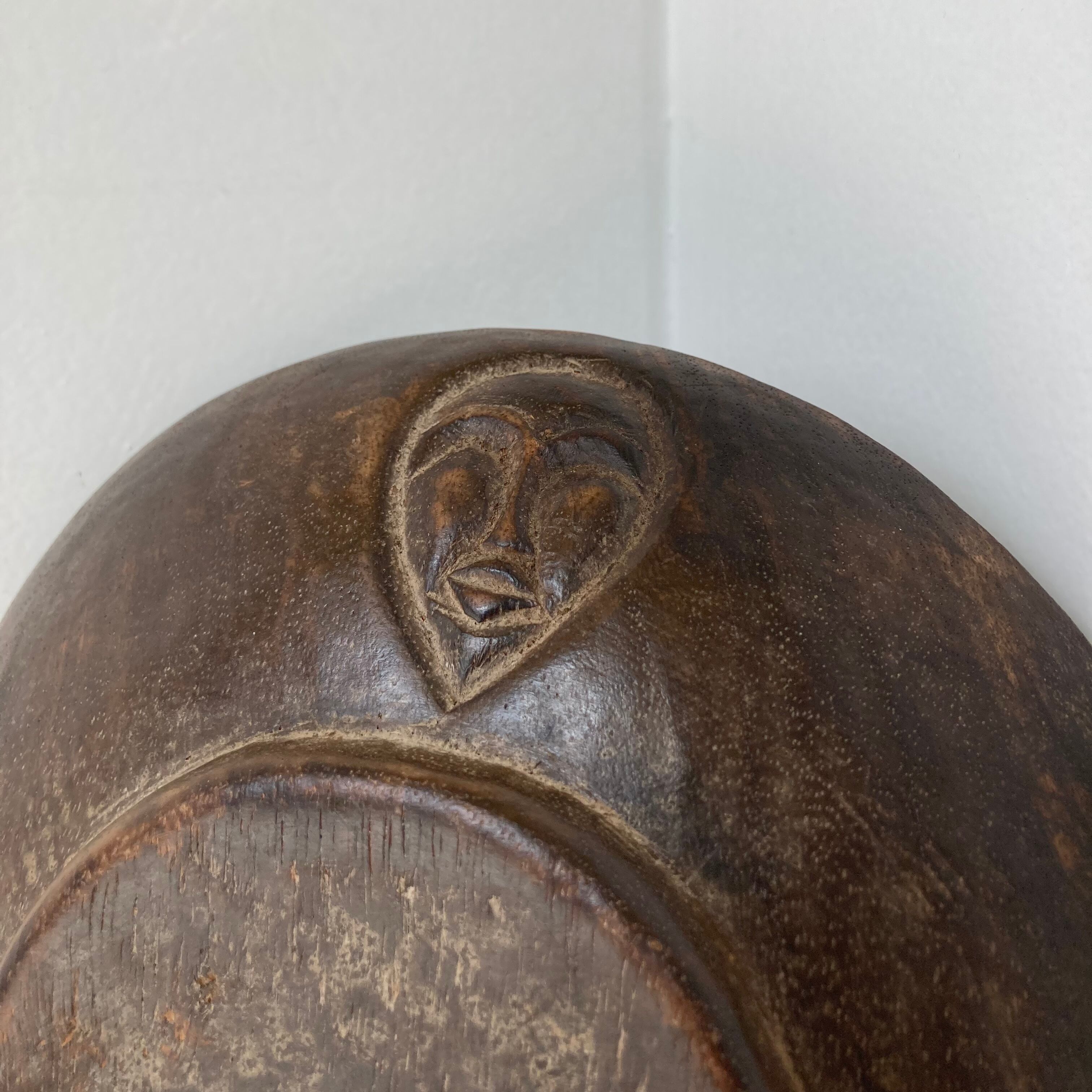 Vintage African tidy in natural wood with carved decoration in flat masks