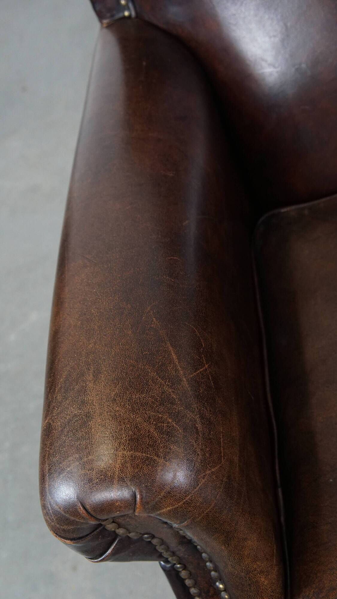 Dark brown sheepskin armchair finished with decorative nails