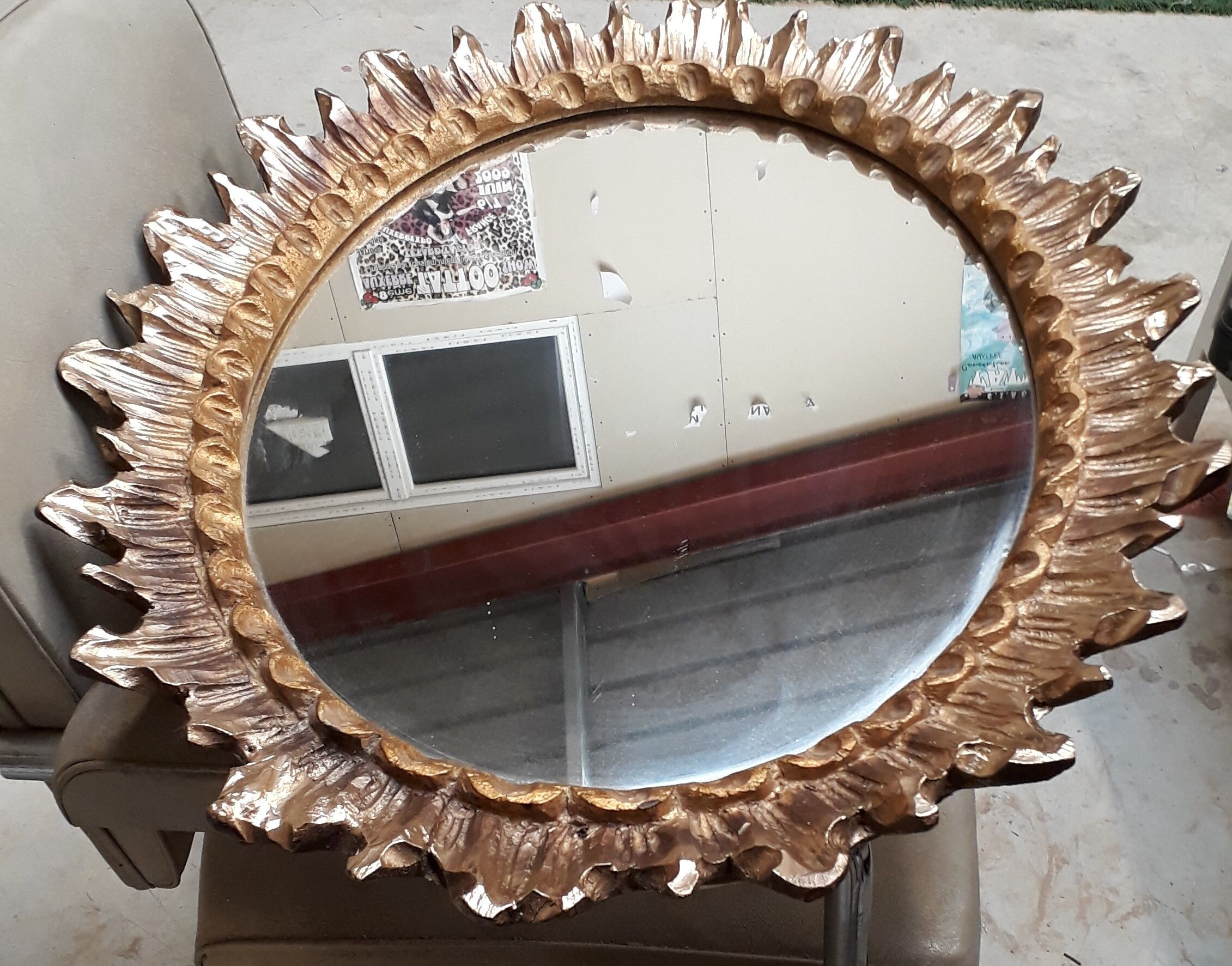 Oval sun mirror made of gilded solid wood