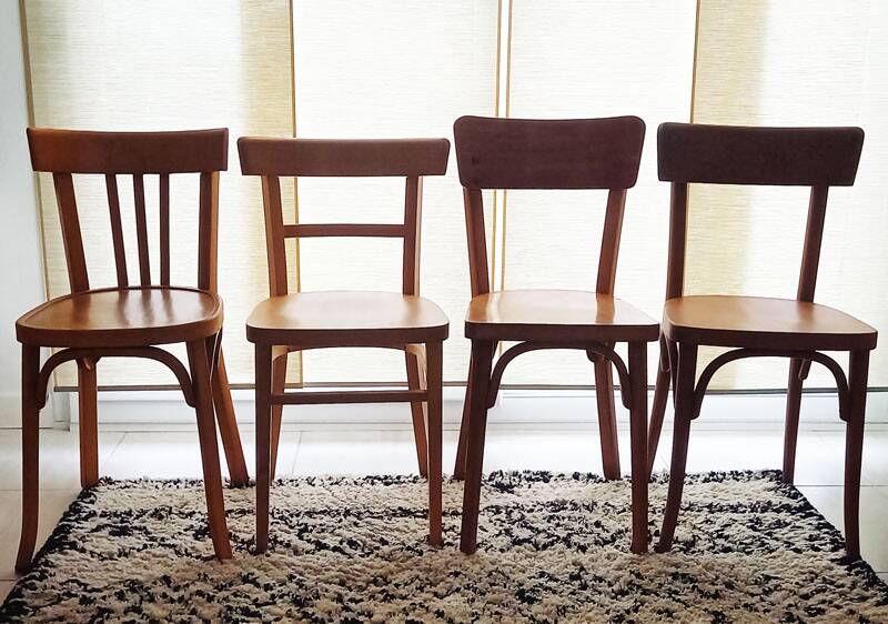 Set of 4 light wood bistro chairs stamped Baumann and Thonet.