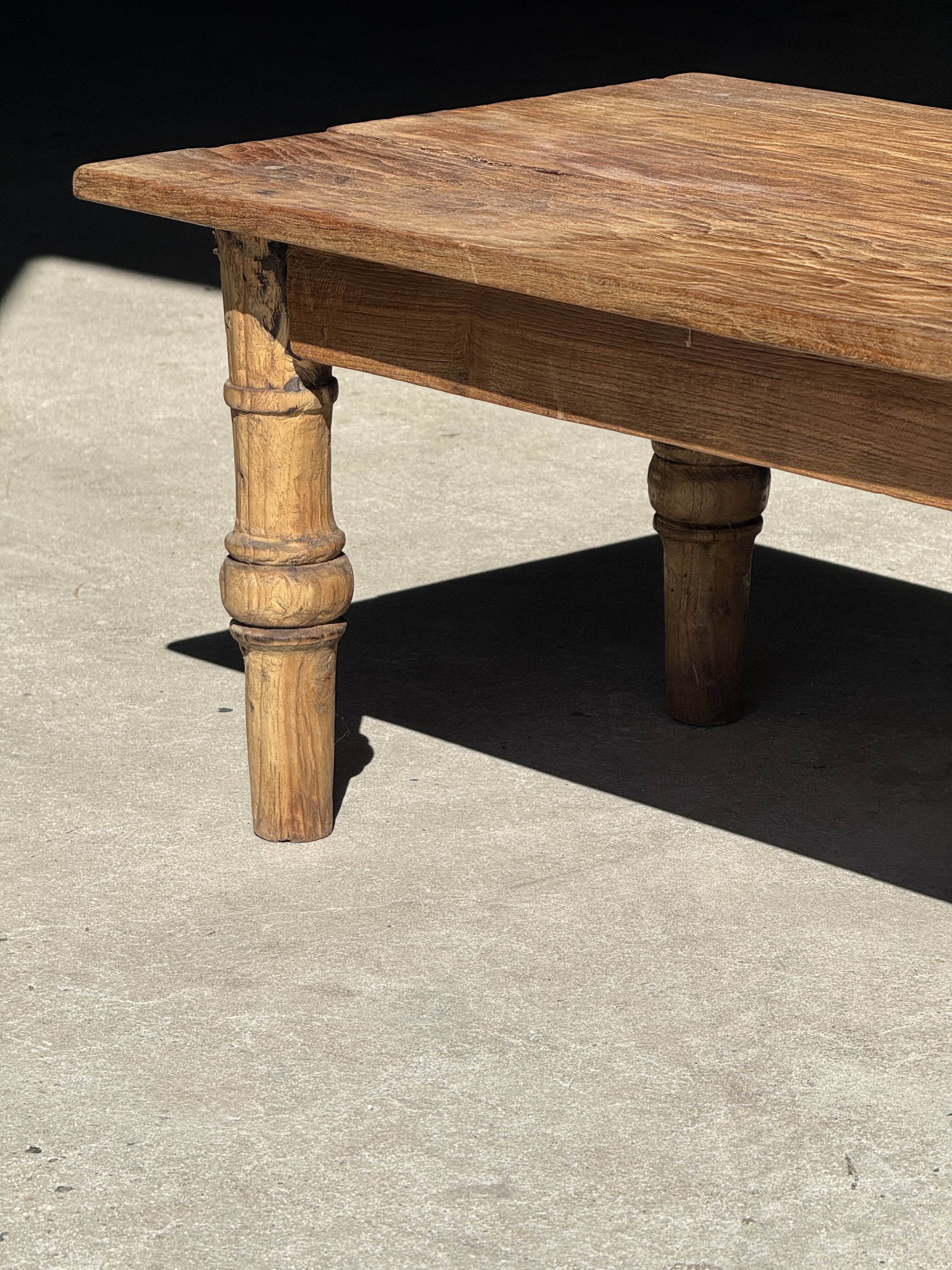 Brown Indonesian teak coffee table, with a border and cylindrical legs H40 L103.