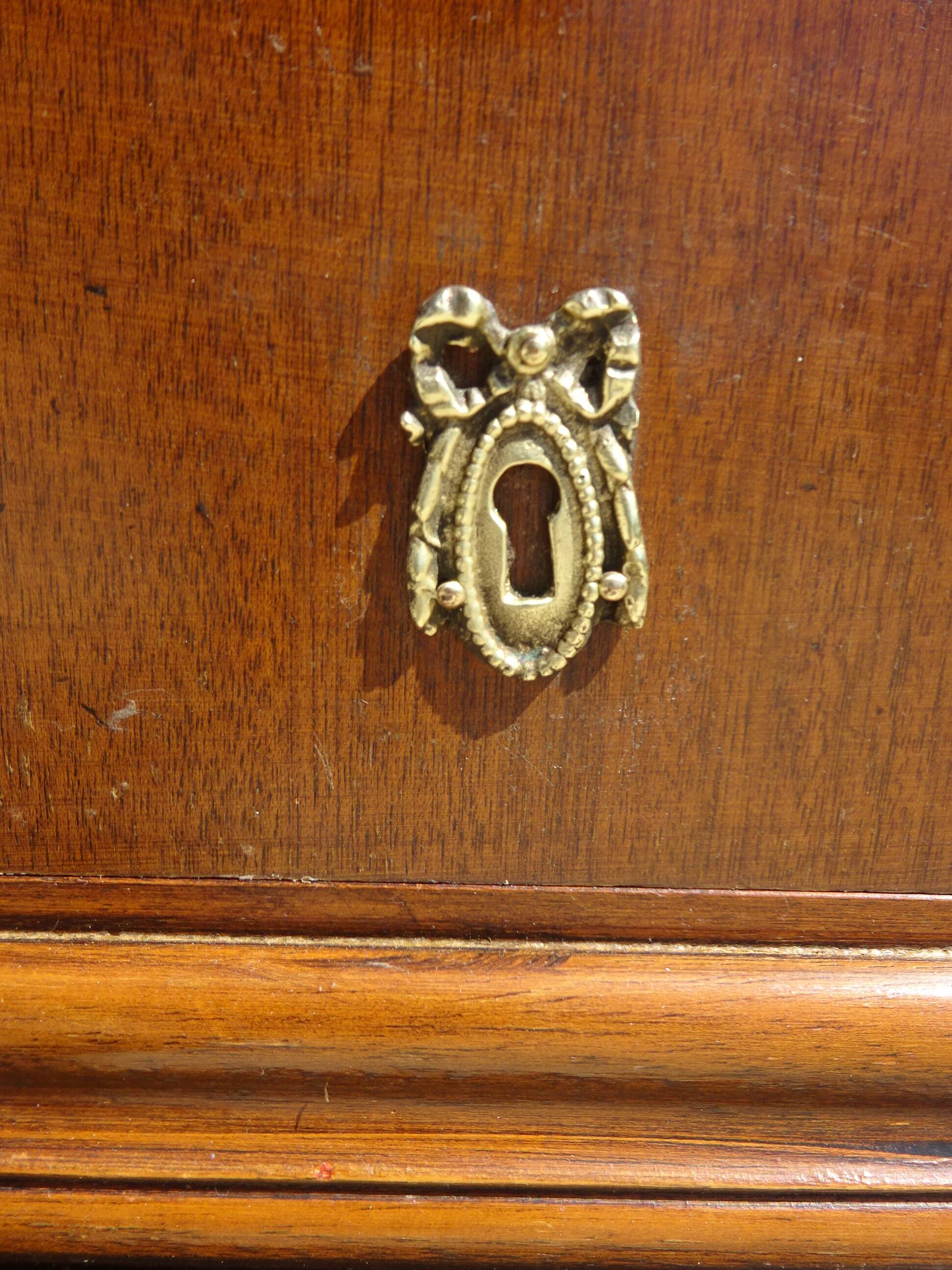 Chest of drawers with decorated handles in the Louis XVI style.