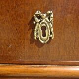 Chest of drawers with decorated handles in the Louis XVI style.