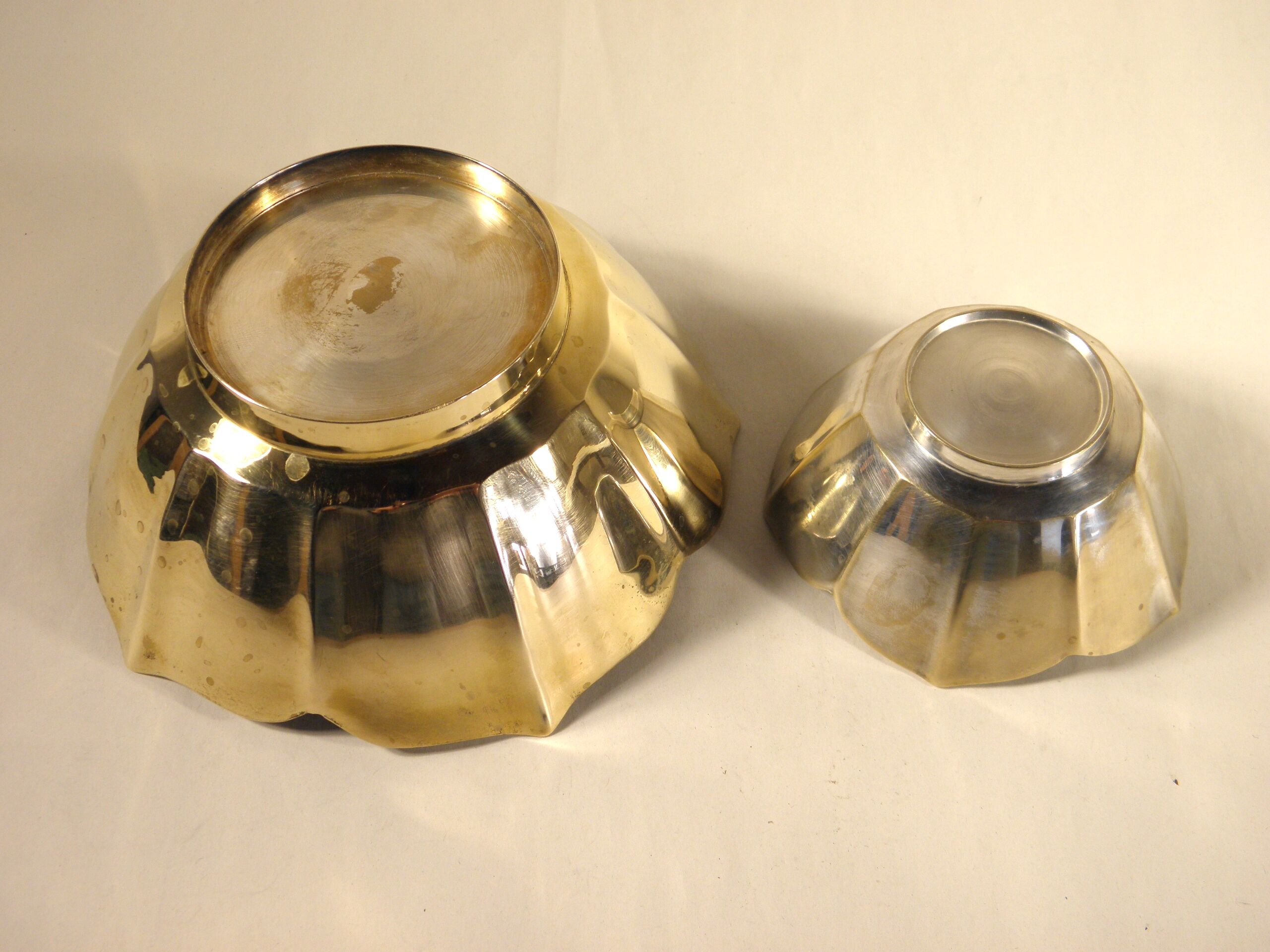Two brass trundle cups