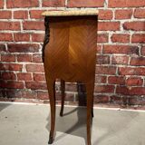 Wooden bedside table topped with a pink marble top