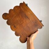 Antique wall shelf with a scalloped edge.
