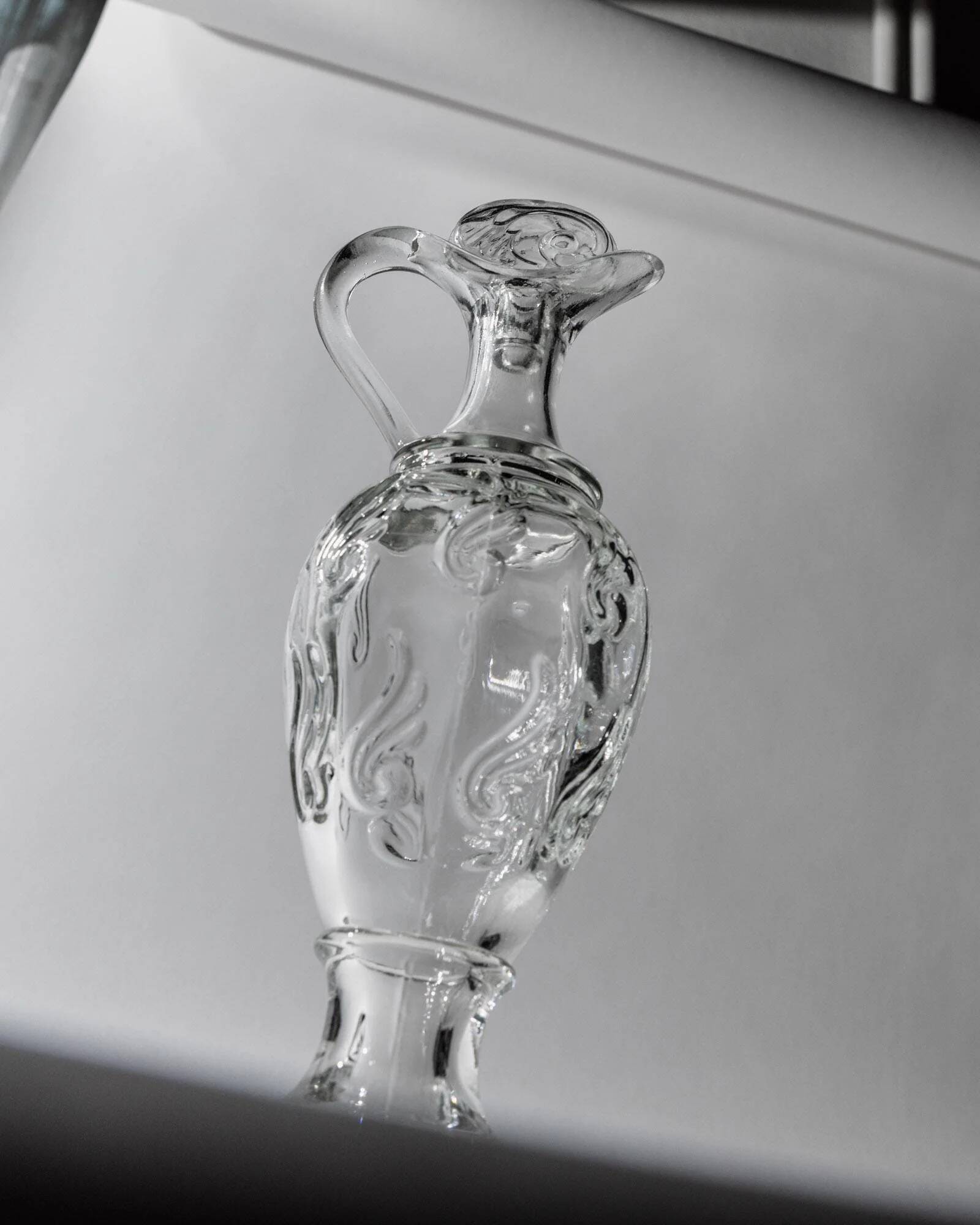 Vintage pressed glass carafe from the 1960s, clear sculptural glass with textured patterns and a stopper.