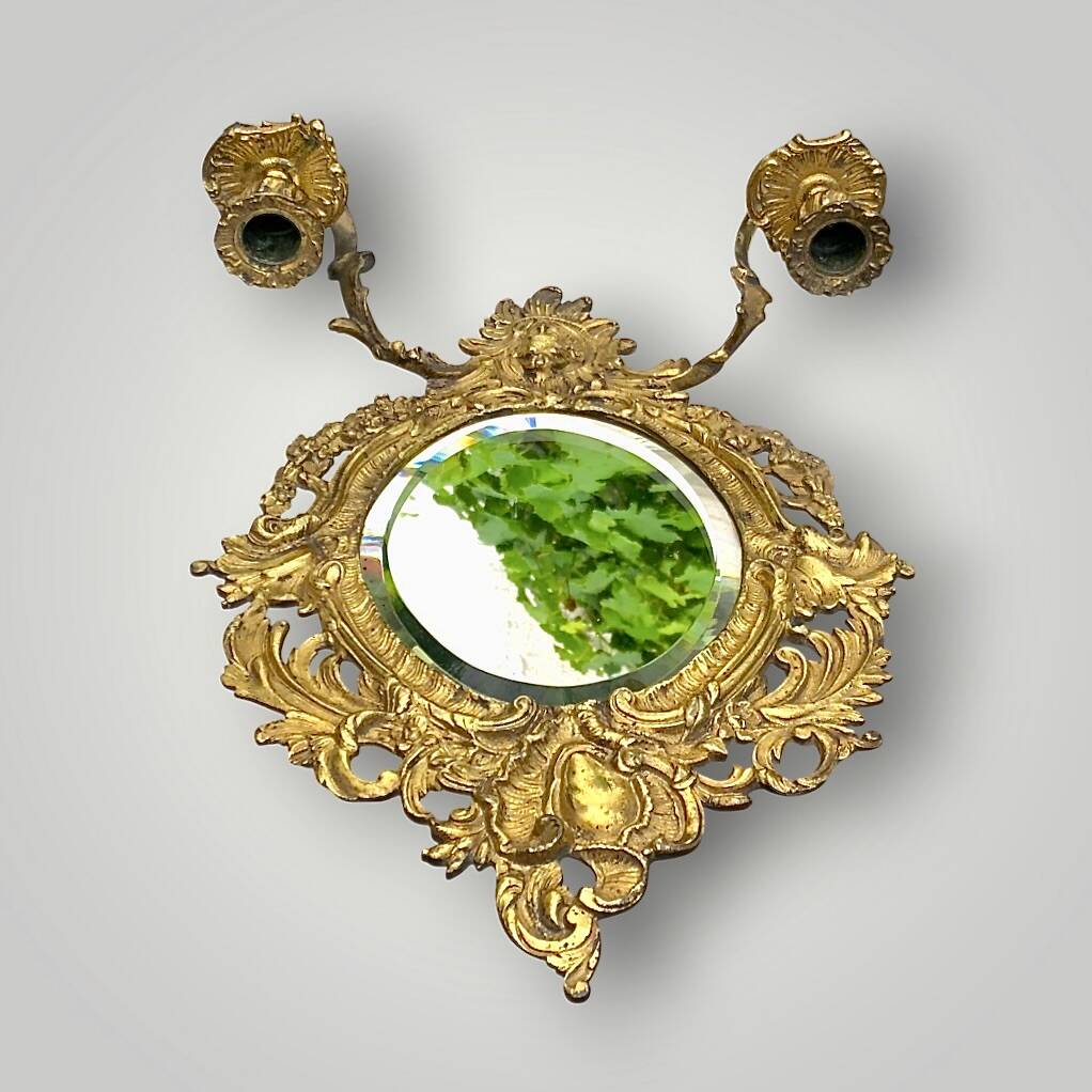 Antique bronze wall sconce with two candlesticks and beveled mirror