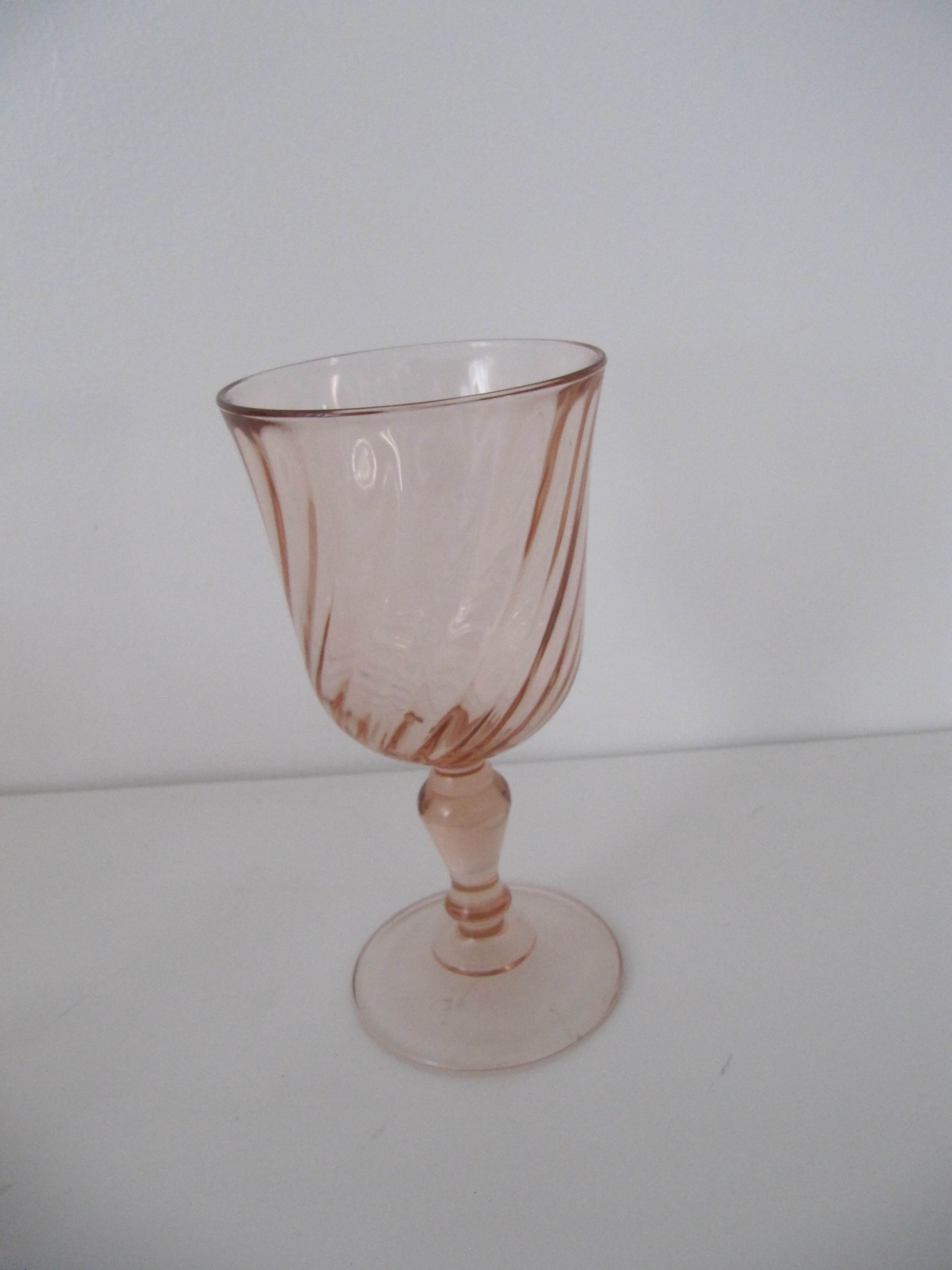 Old bottle in pink glass and 2 wine glasses