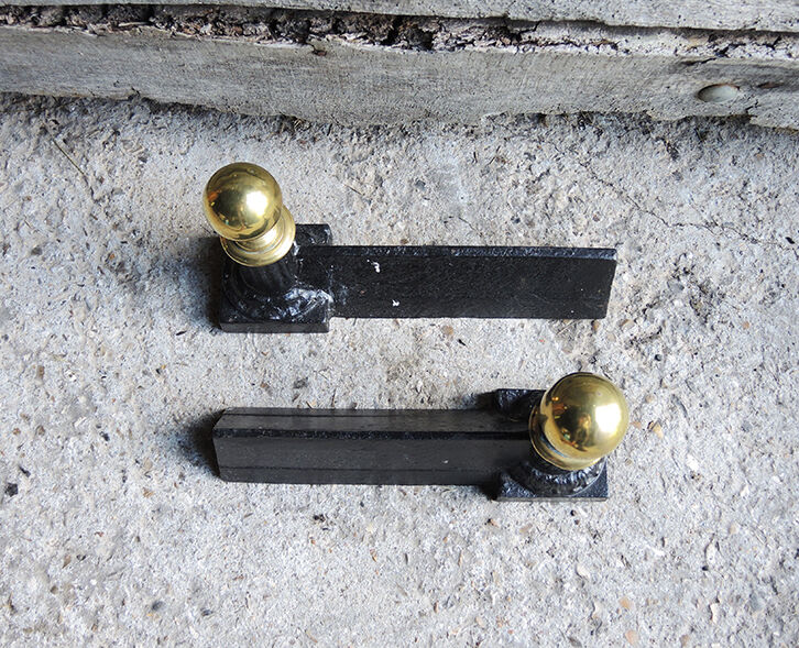 Old cast iron and brass andirons in neoclassical style
