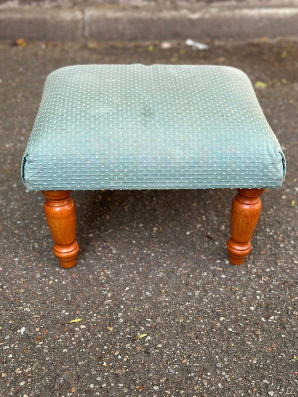 Vintage footstool made of solid wood and blue fabric.