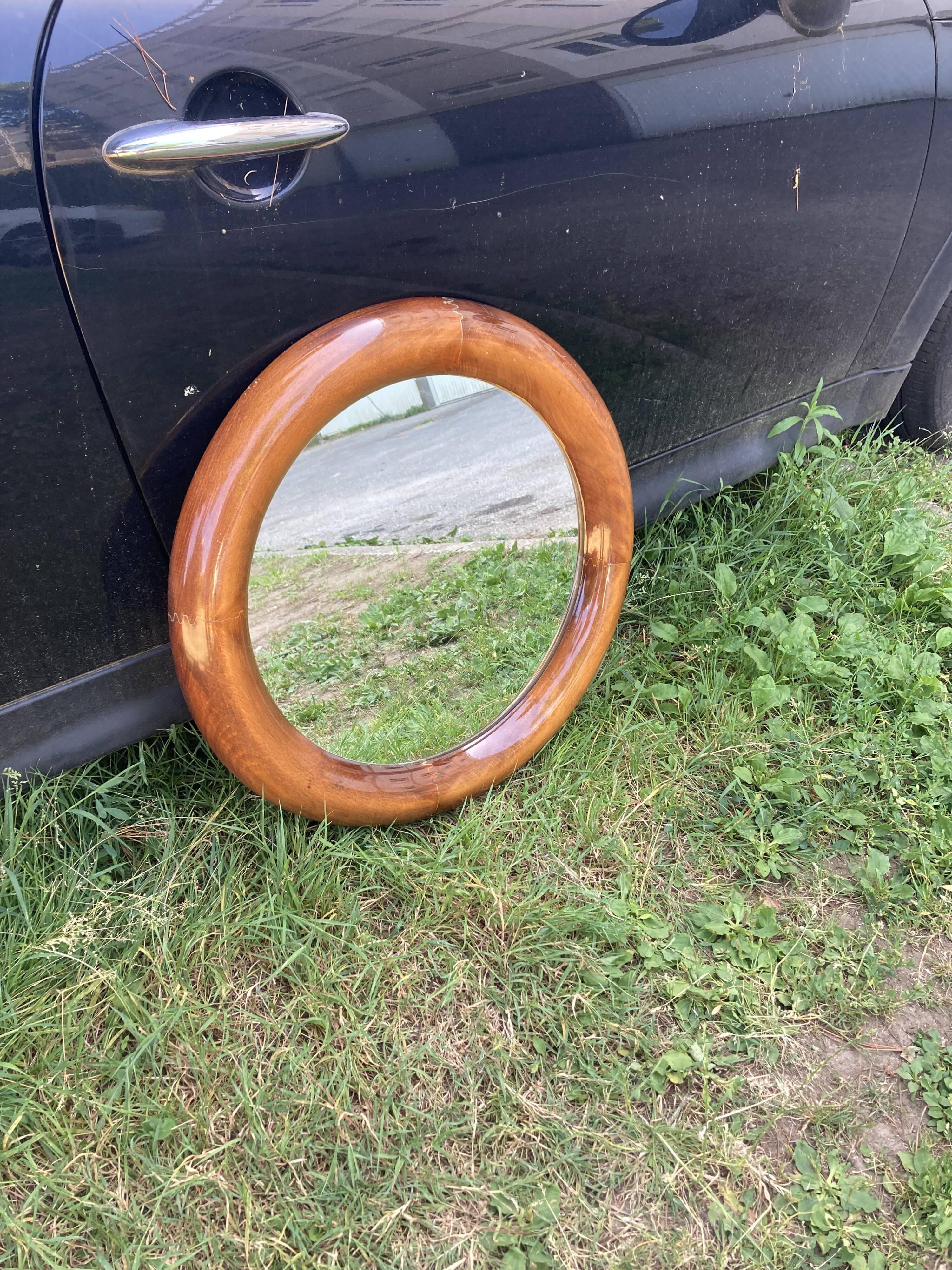 Round varnished wooden mirror