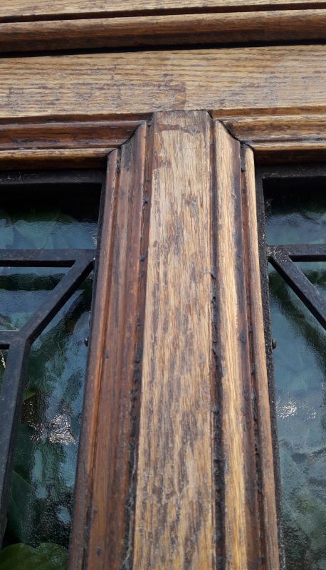 Oak entrance door and its frame and transom, wrought iron gates