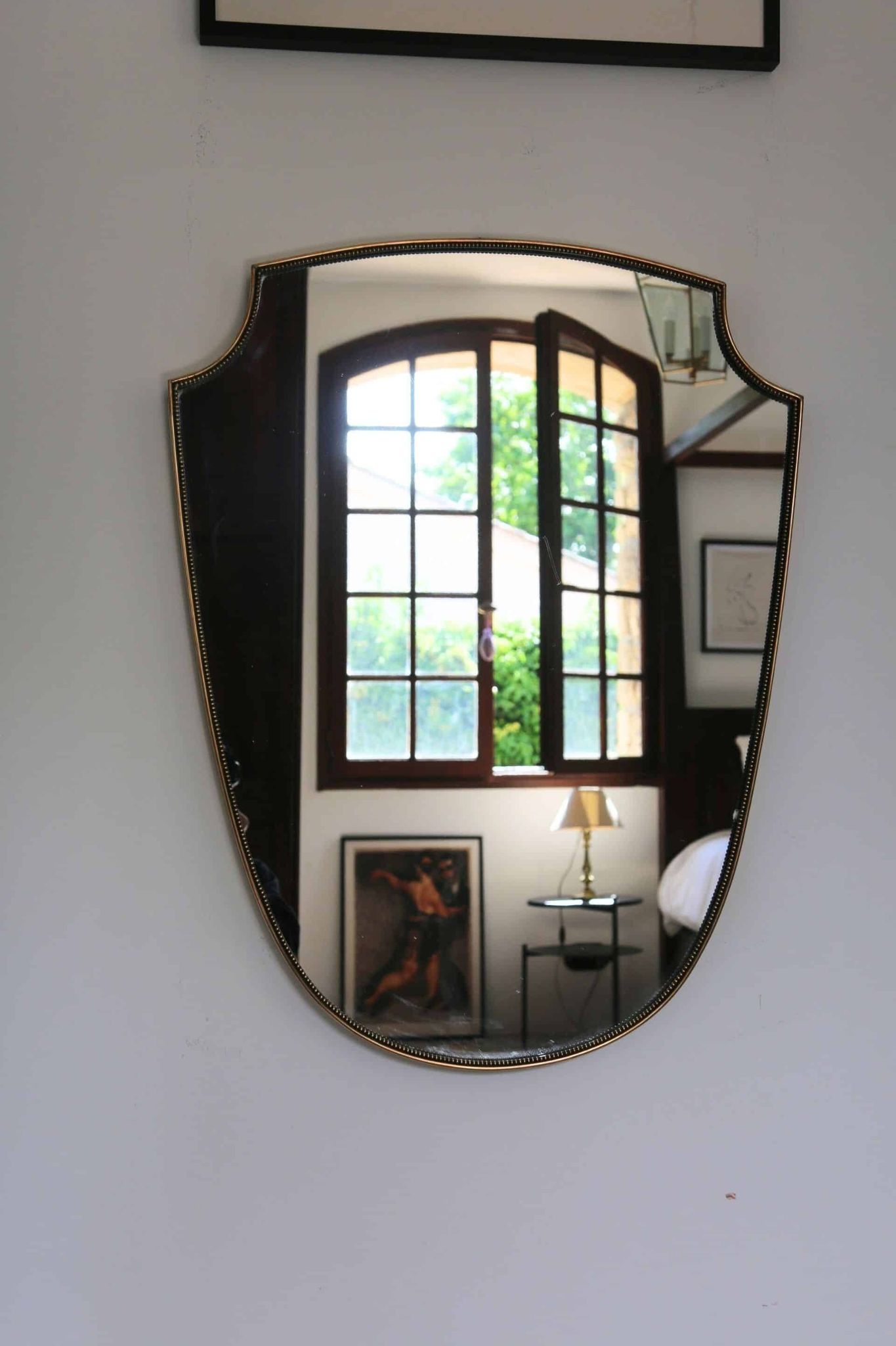 Miroir écusson en laiton à frise perlée de style italien