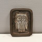 Small relief with a motif of an owl emerging from the back plate.