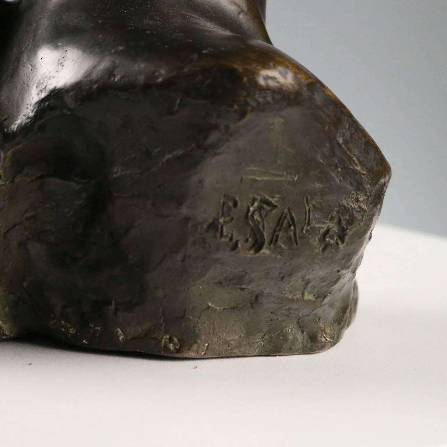 Ancient sculpture of a young woman's face in bronze, 19th-20th century.