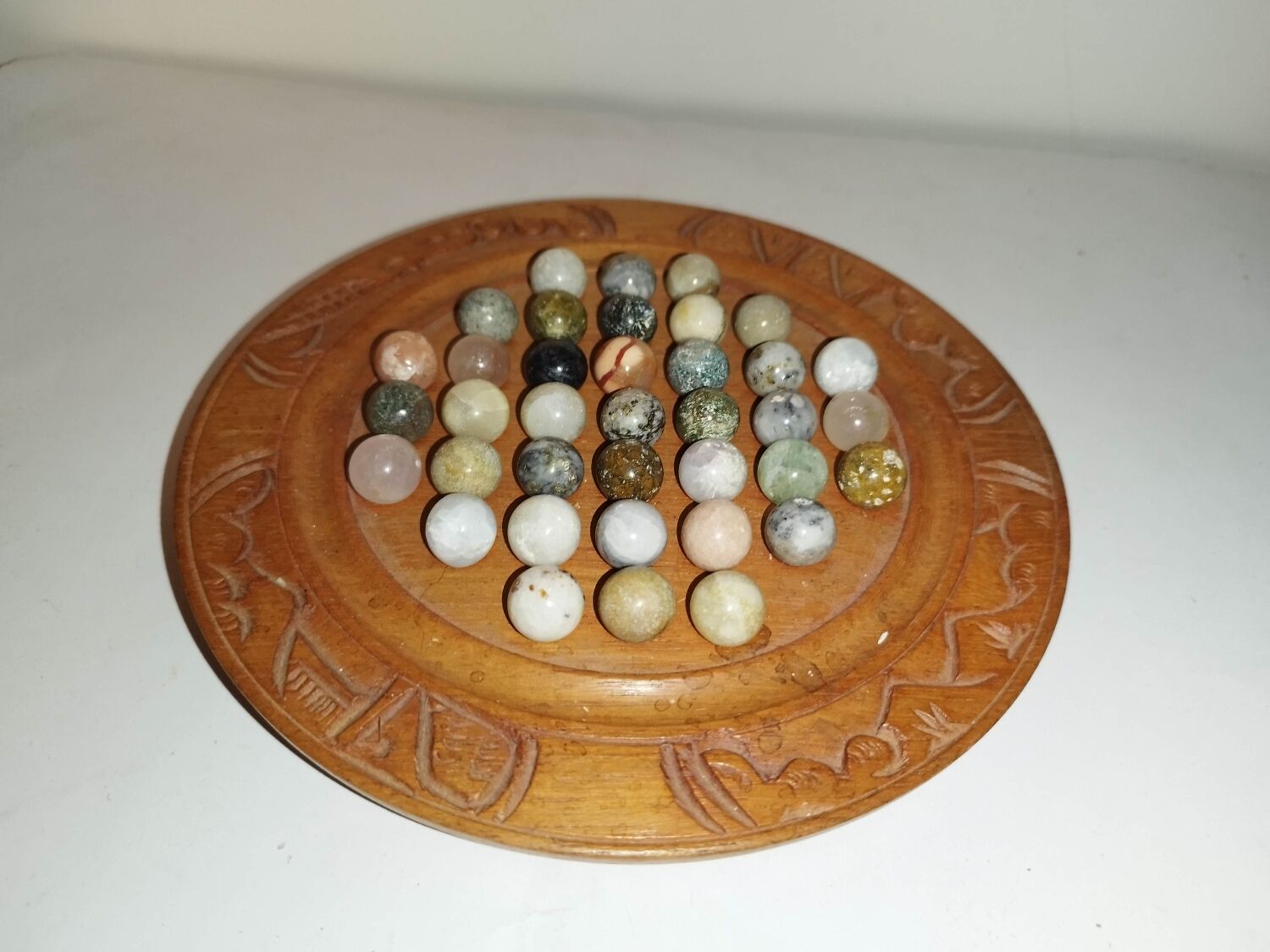 Ancient solitaire game in wood and stone marbles