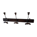 old wall coat holder made up of 3 wooden and metal pads.