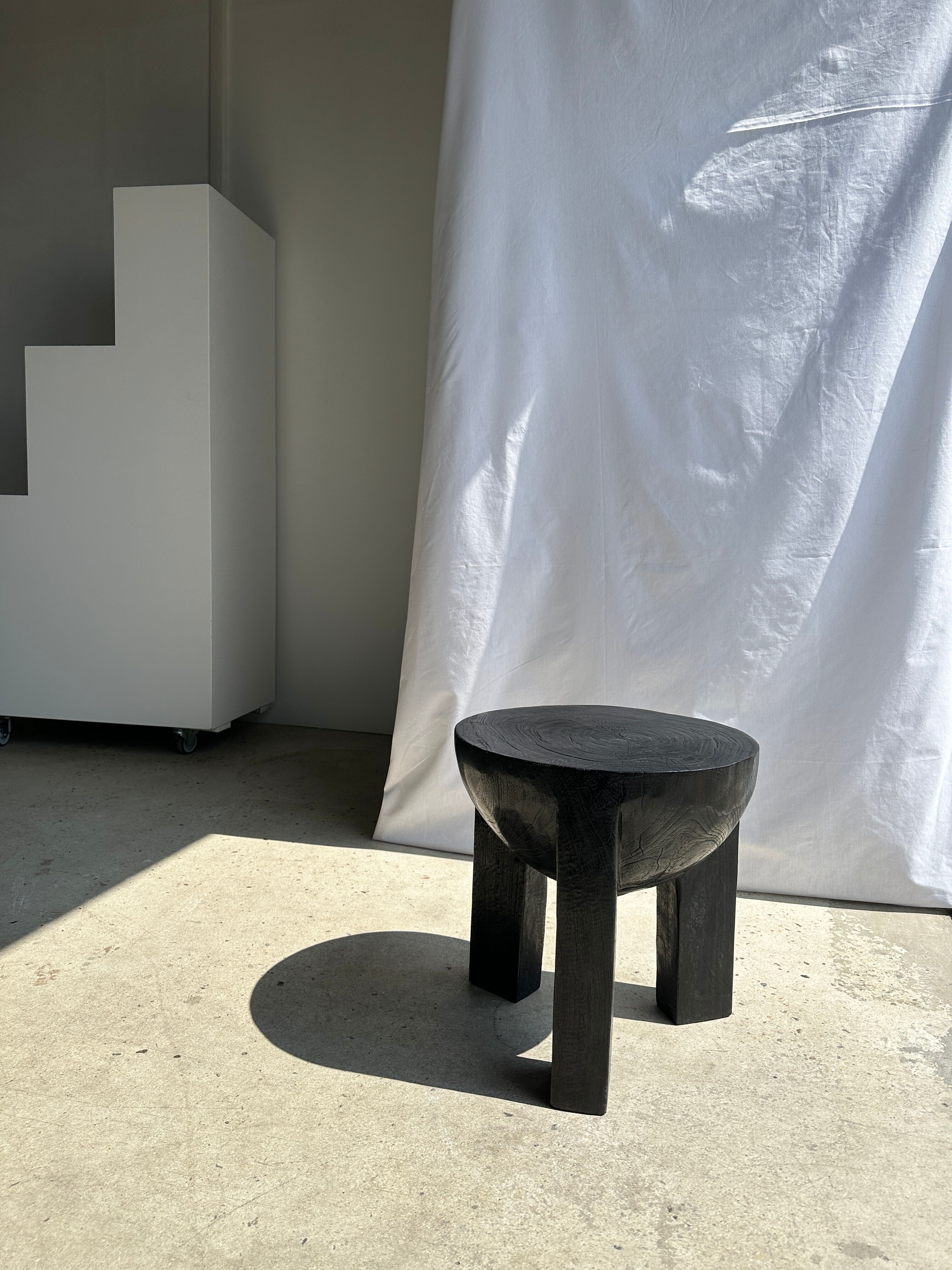 Black mango wood tripod side table with a semi-spherical top, height: 45 cm, diameter: 44 cm.