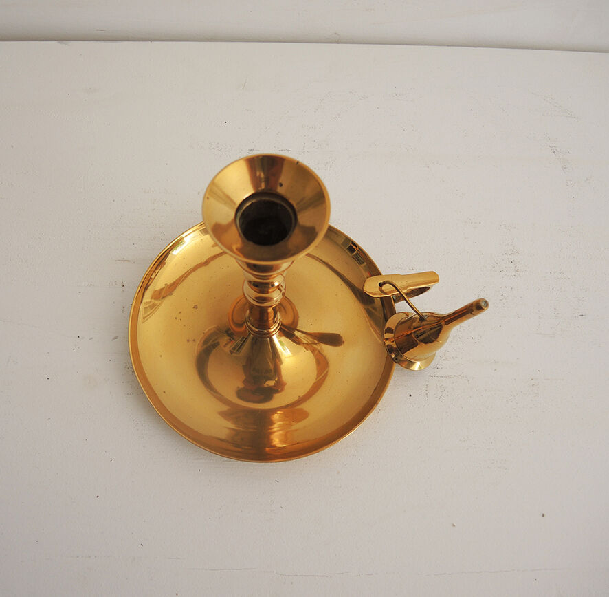 Old candlestick with brass extinguisher.